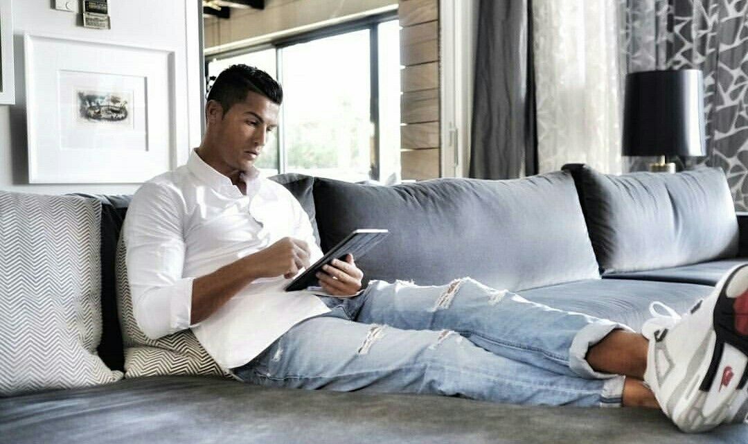 Cristiano Ronaldo relaxes on a couch in his home