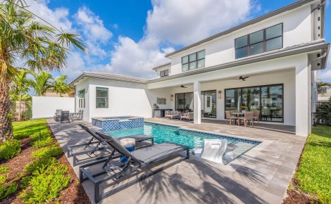 Modern luxury backyard with swimming pool and outdoor living space at Lotus Edge, Boca Raton, showcasing Itchko Ezratti’s GL Homes development with high-end finishes and tropical landscaping.