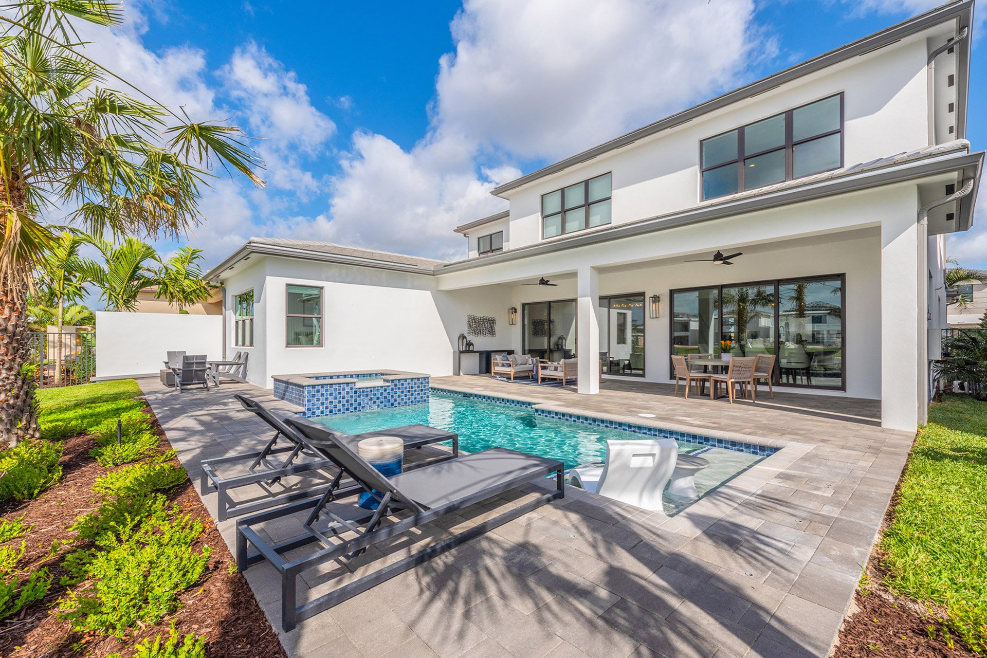Modern luxury backyard with swimming pool and outdoor living space at Lotus Edge, Boca Raton, showcasing Itchko Ezratti’s GL Homes development with high-end finishes and tropical landscaping.