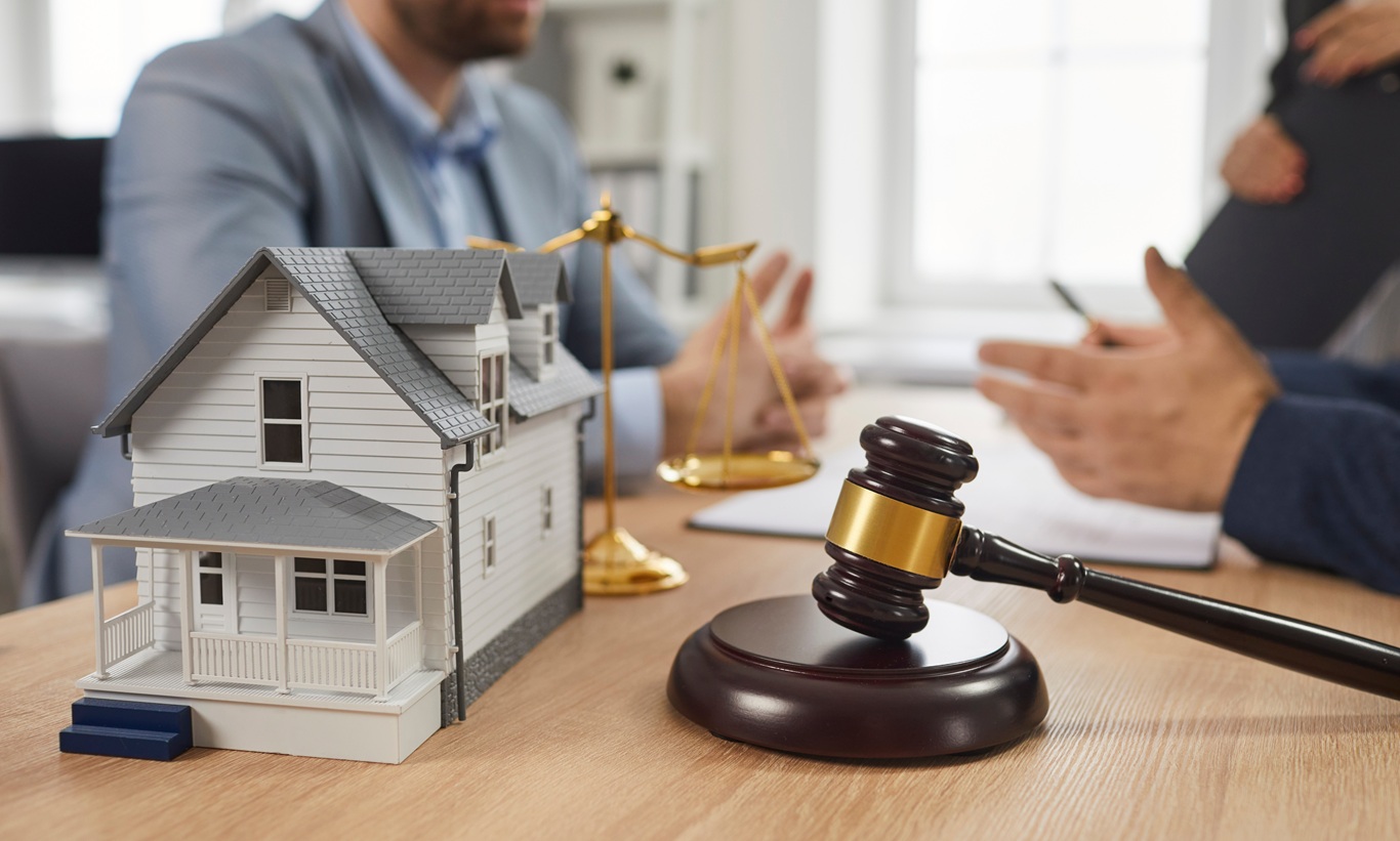people meeting and talking at office table with gavel and residential house model