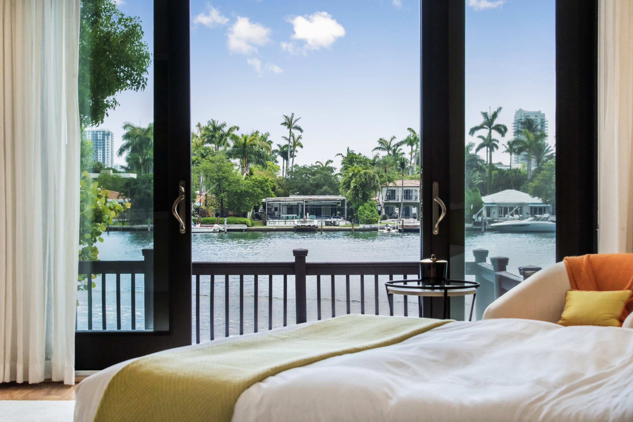 Bedroom with large windows overlooking a waterfront canal
