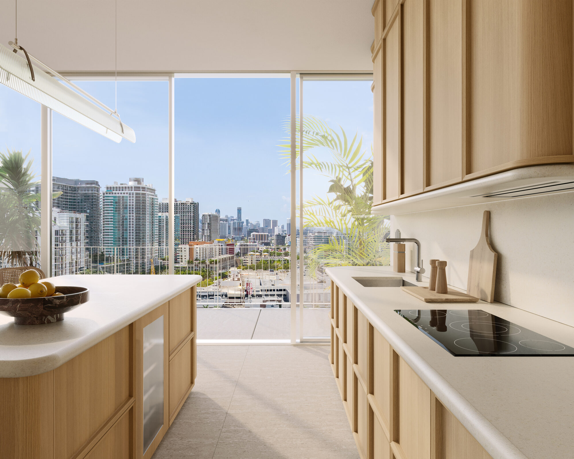 Warm oak kitchen cabinetry and cream stone at Fouquet's Hotel & Residences Miami Design District